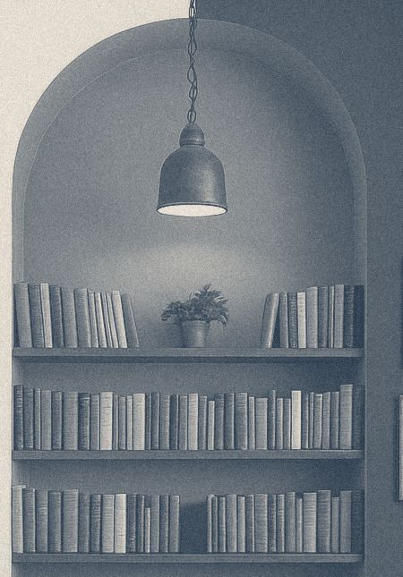 An arched niche of books under a hanging lamp